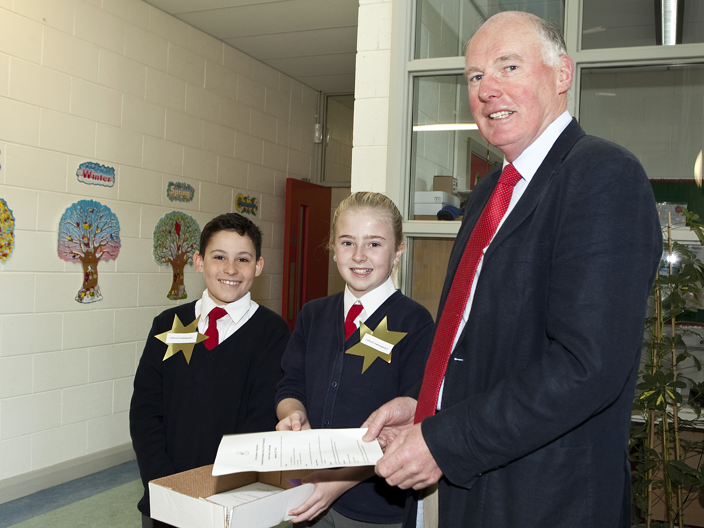 Lt. Col Gerry O\'Gorman (Rtd) is greeted by David Rogan and Claudia Murray -two school ambassadors from 6h class - as he arrives at St. Anne\'s School, Ardclough for the Presentation of the National Flag and 1916 Proclamation to the school.