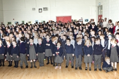 Pupils and tachers stand to sing The National Anthem