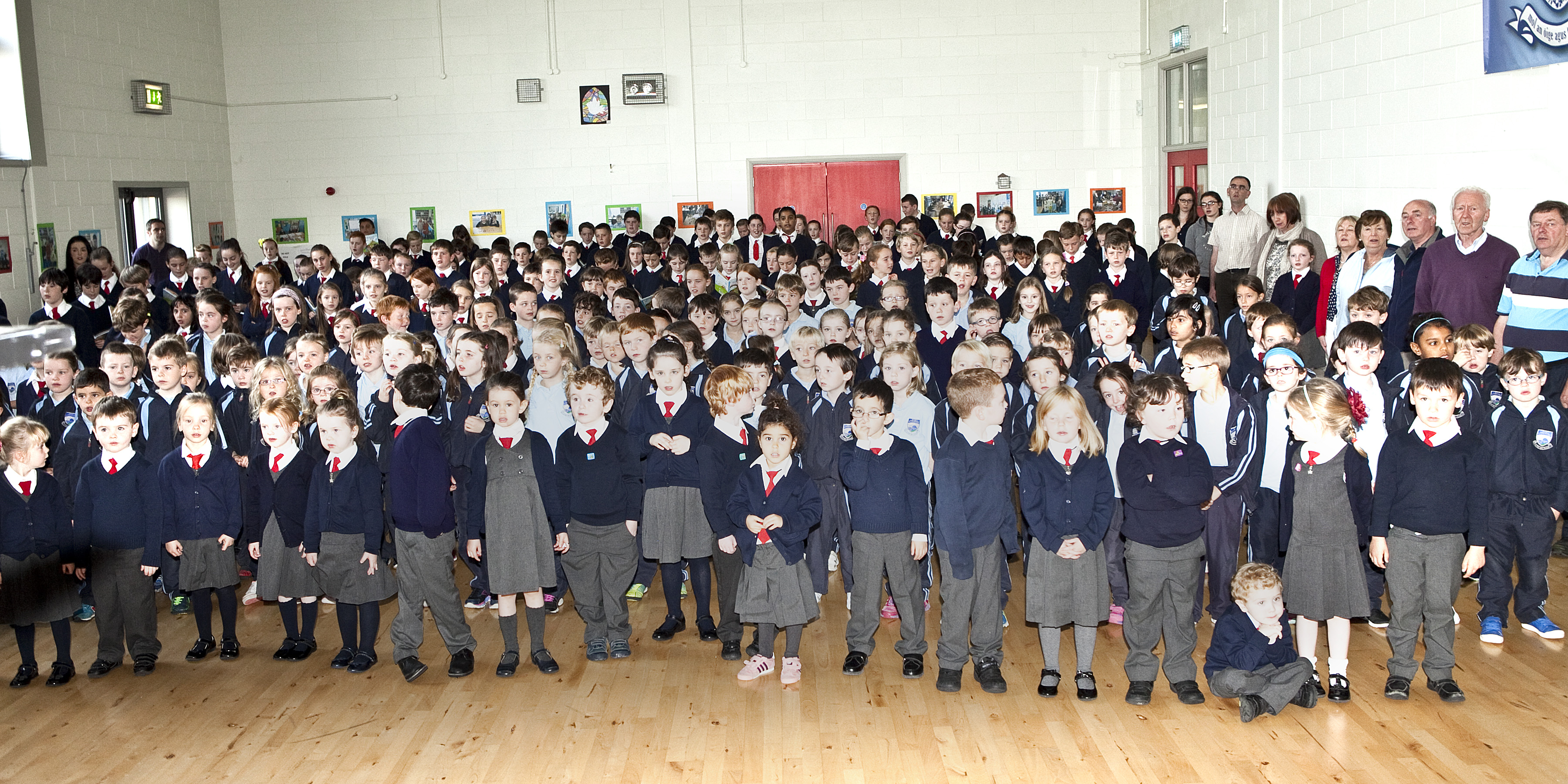 Pupils and tachers stand to sing The National Anthem